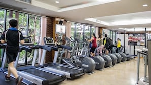 A gym with treadmills, stationary bikes, and elliptical machines.