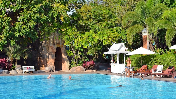 A swimming pool with lounge chairs and a gazebo.