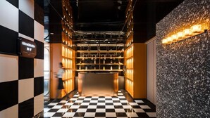 A checkered floor, a bar area with shelves, and a textured wall. - Paco Hotel Tiyuxilu Metro Guangzhou (Guangzhou)
