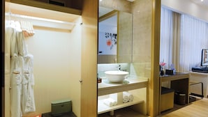 Un baño moderno con un espejo grande, un lavabo blanco y un mueble de tocador de madera.