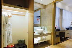 A modern bathroom with a large mirror, a white sink, and a wooden vanity. - Paco Hotel Tiyuxilu Metro Guangzhou (Guangzhou)