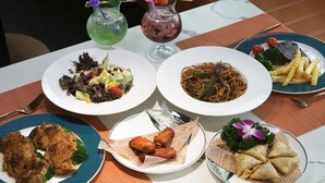 A table with various dishes including pasta, salad, and fried items, along with two drinks. - Paco Hotel Tiyuxilu Metro Guangzhou (Guangzhou)