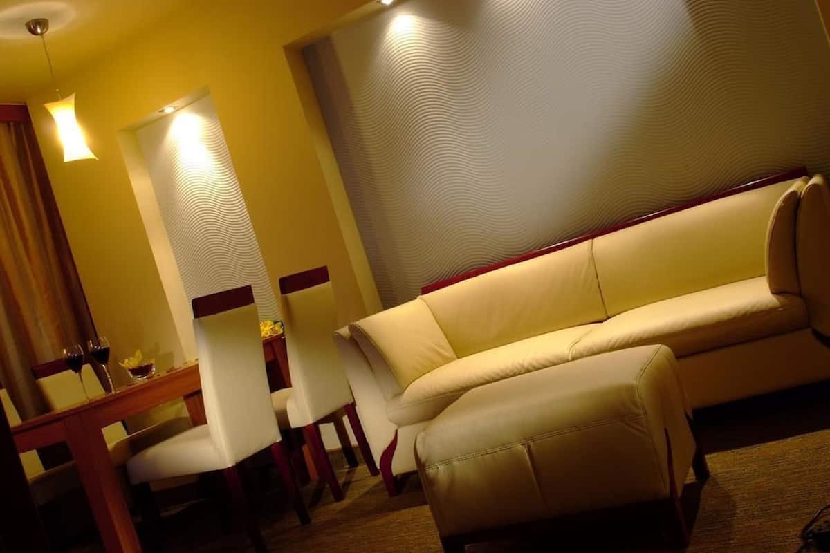 A dining area with a sofa, chairs, and a table.