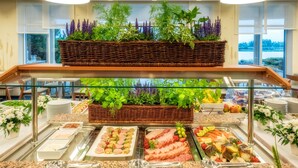 A buffet with various food items and fresh plants. - Hotel Hp Park (Poznan)