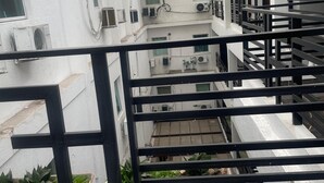 A modern building with a central atrium, multiple air conditioning units, and a staircase with black railings. - Hotel Family (São Paulo)