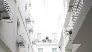 A multi-level courtyard with balconies, potted plants, and outdoor seating areas. - Hotel Family (São Paulo)