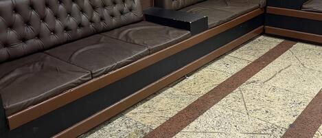 Una sala de estar moderna con un sofá modular grande, un cuadro abstracto enmarcado y un revestimiento de pared de madera.