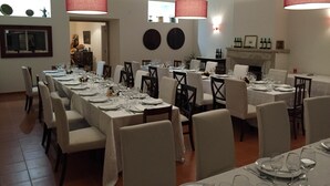 A dining area with multiple tables set for a meal, featuring white tablecloths and chairs, and large red lamps hanging from the ceiling. - Casa do Alfaro (Azambuja)