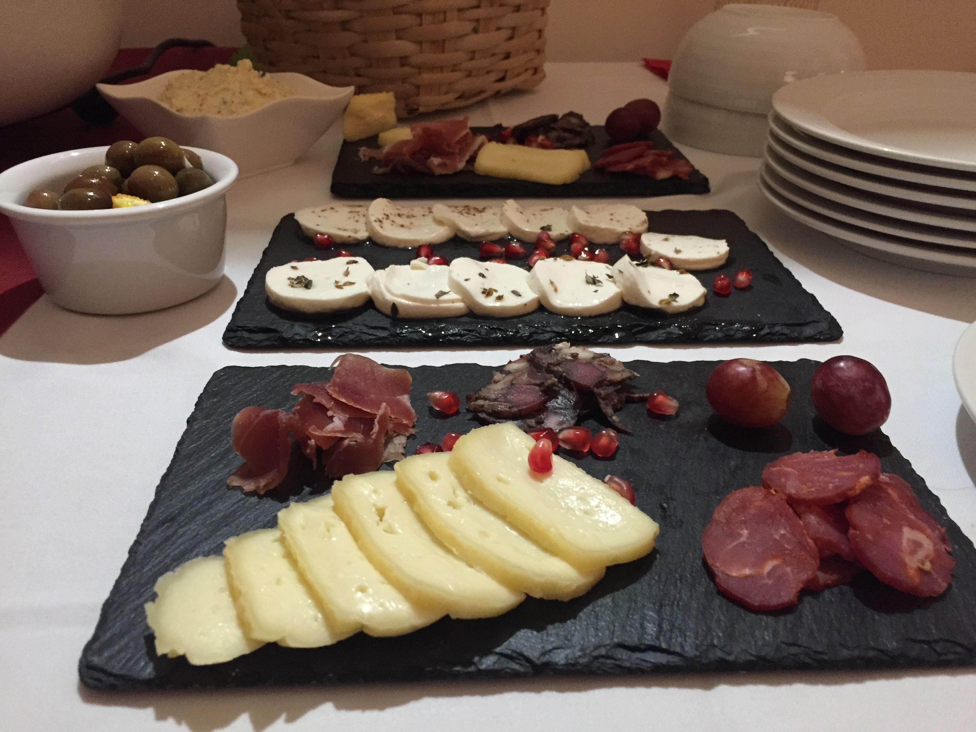 A table with various food items including cheese, olives, and meats.