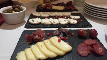 A table with various food items including cheese, olives, and meats.