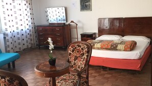 A bedroom with a bed, a desk, a chair, a dresser, and a blue sofa. - Ca' Barbaria (Venice)