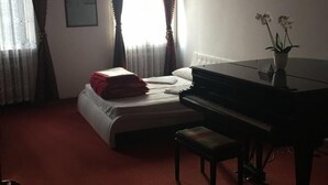 A hotel room with a bed, a piano, and a small table. - Ca' Barbaria (Venice)