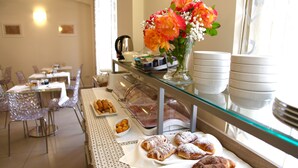 A breakfast buffet with pastries and flowers. - Palazzo Ruschioni Boutique Hotel (Camerano)