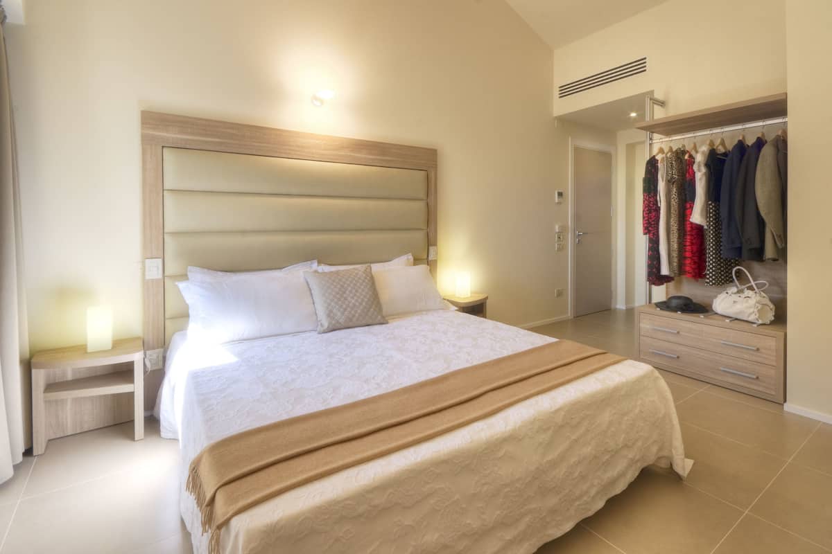 A bedroom with a large bed, bedside tables, a wardrobe, and a closet.