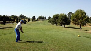 A golf course with a clear path, trees, and a golfer preparing to hit a ball. - Palazzo Ruschioni Boutique Hotel (Camerano)