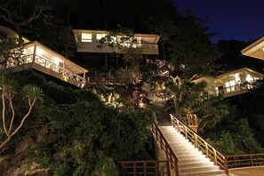 Ein mehrgeschossiges Haus mit einer Treppe, die die verschiedenen Etagen verbindet, umgeben von üppigem Grün.