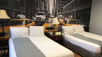 Ein Hotelzimmer mit zwei Betten, einem Nachttisch und einer Wandmalerei einer Stadtstraße mit Taxis.