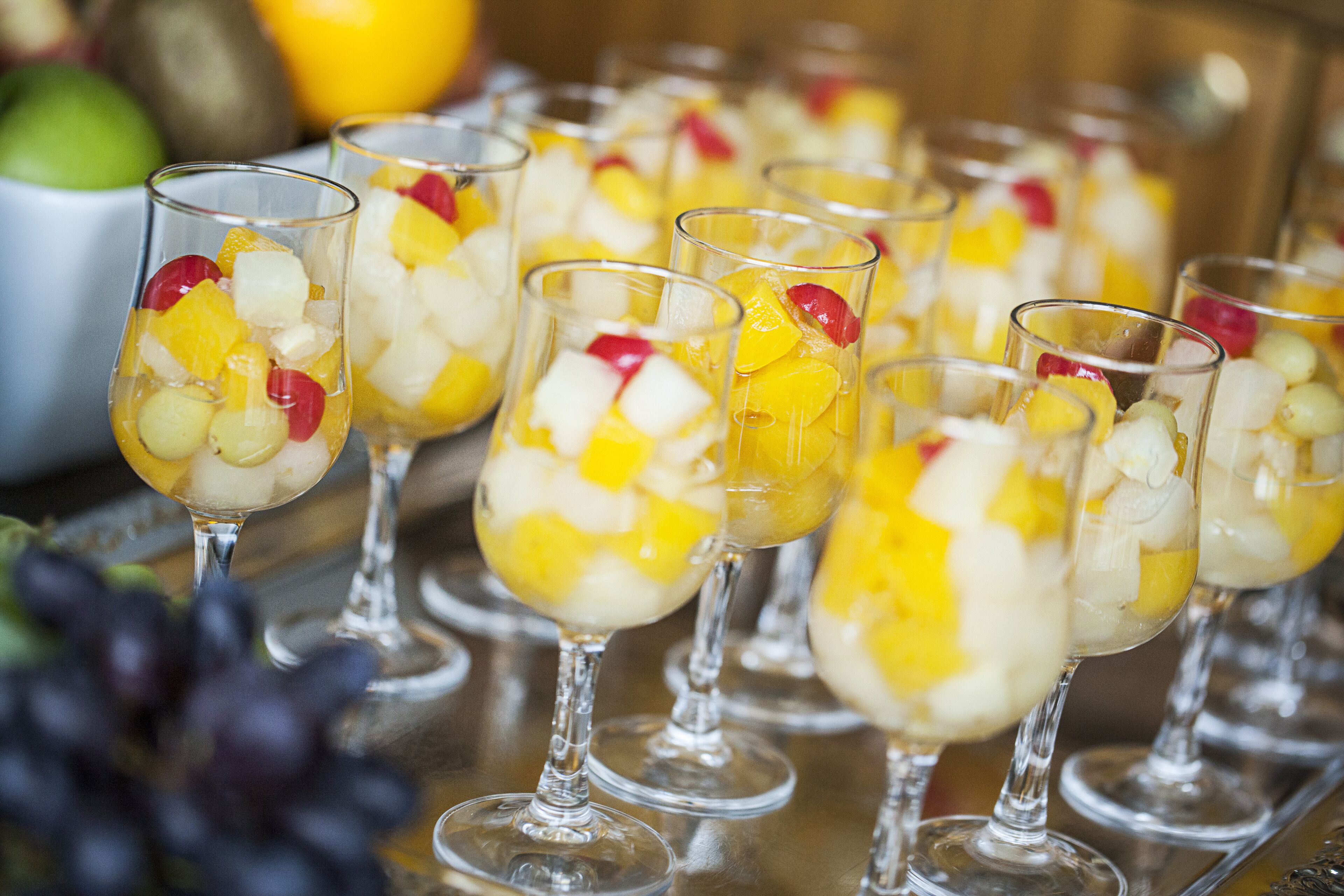Glazen met fruit en ijsblokjes in een rij.