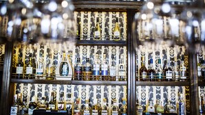 Un bar con varias estanterías llenas de botellas de licor.
