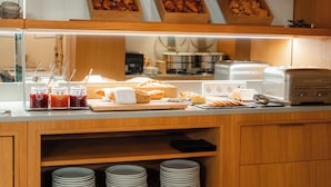 A breakfast buffet with pastries, bread, and condiments. - 9Hotel Sablon (Brussels)
