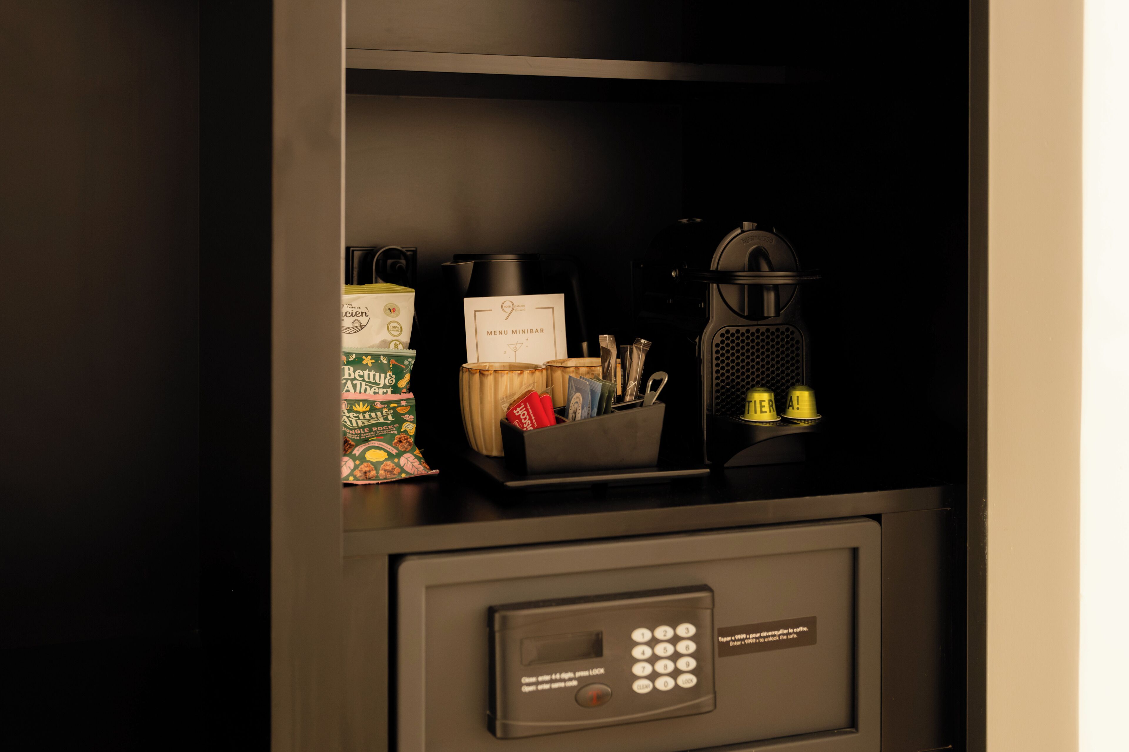A minibar with a coffee maker, a bottle of water, and a small refrigerator.
