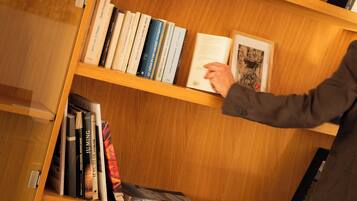 Una estantería de madera con libros y un cuadro enmarcado.