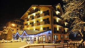 Un hôtel à plusieurs étages, doté de balcons et dont le sol est recouvert de neige.