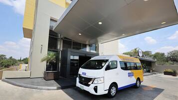Una camioneta blanca y amarilla estacionada frente a un edificio con un letrero que dice 'CITY EXPRESS'.