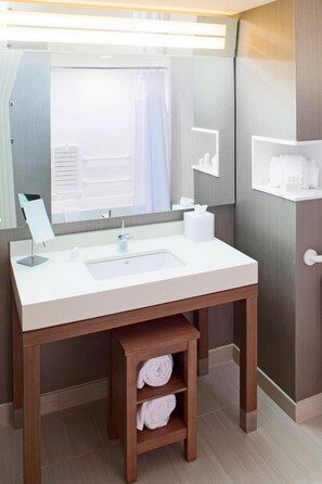 Enjoy a clean and contemporary bathroom with a large mirror, sink, and modern faucet.