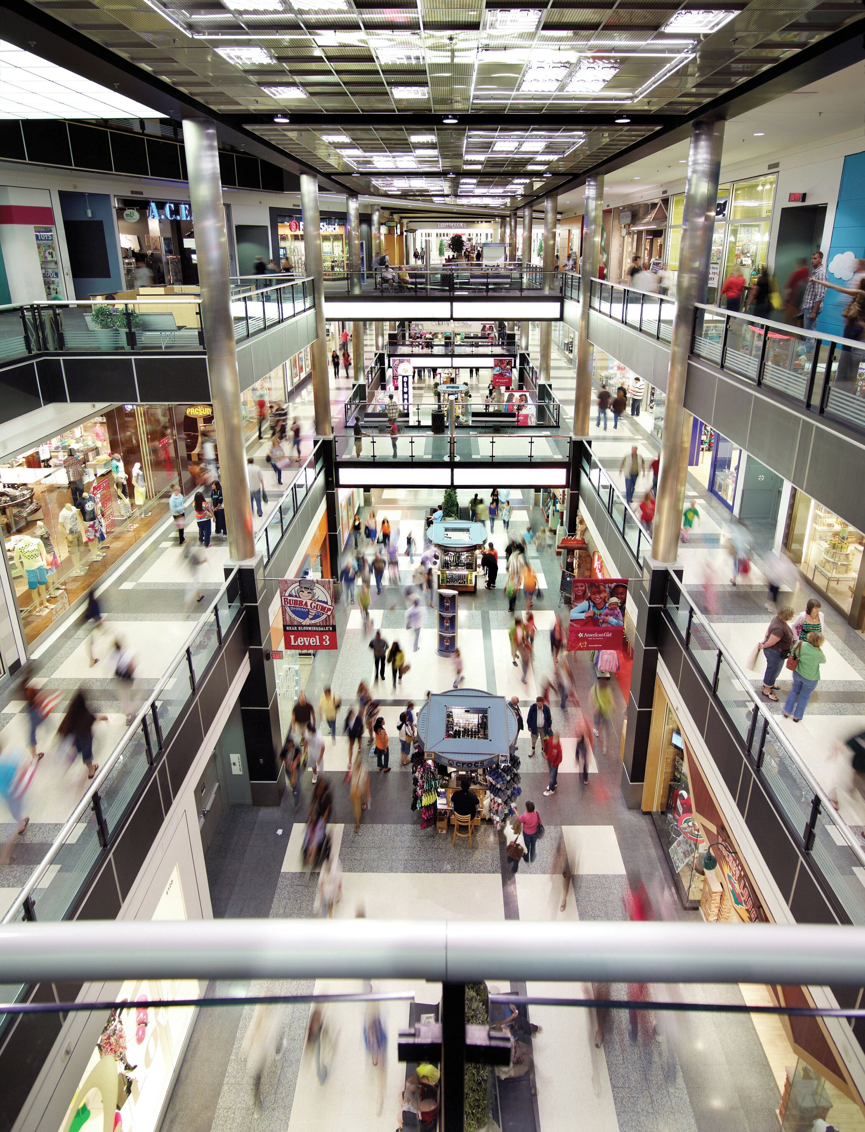 A multi-level shopping mall with various stores and a central kiosk area.