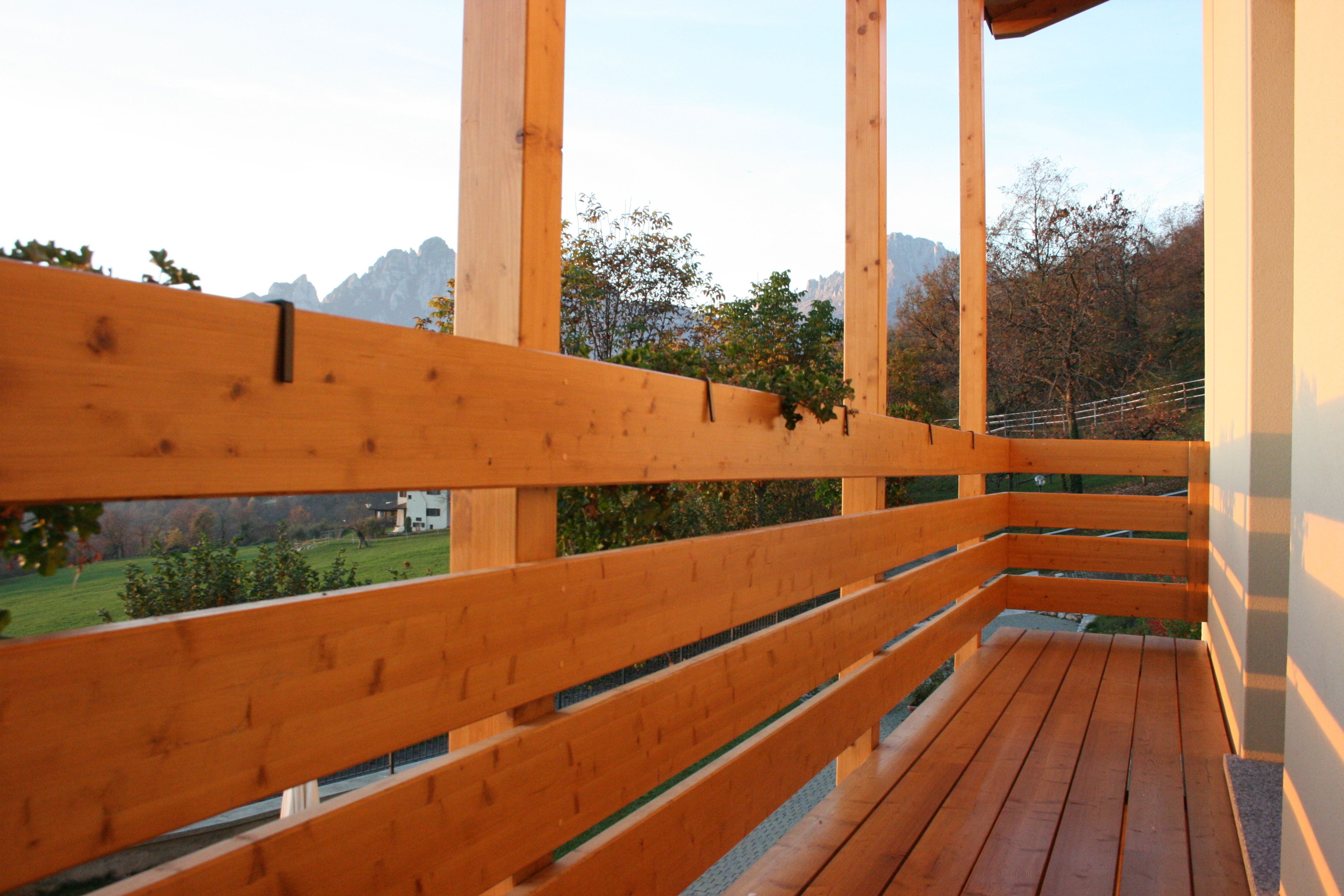 Un balcone in legno con vista su un paesaggio montano.
