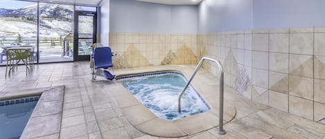 Un espace spa comprenant un bain à remous, des sièges et une vue sur une montagne enneigée.