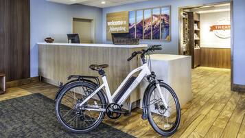 A reception area with a reception desk, a bicycle, and a wall sign that reads "welcome to Hampton."
