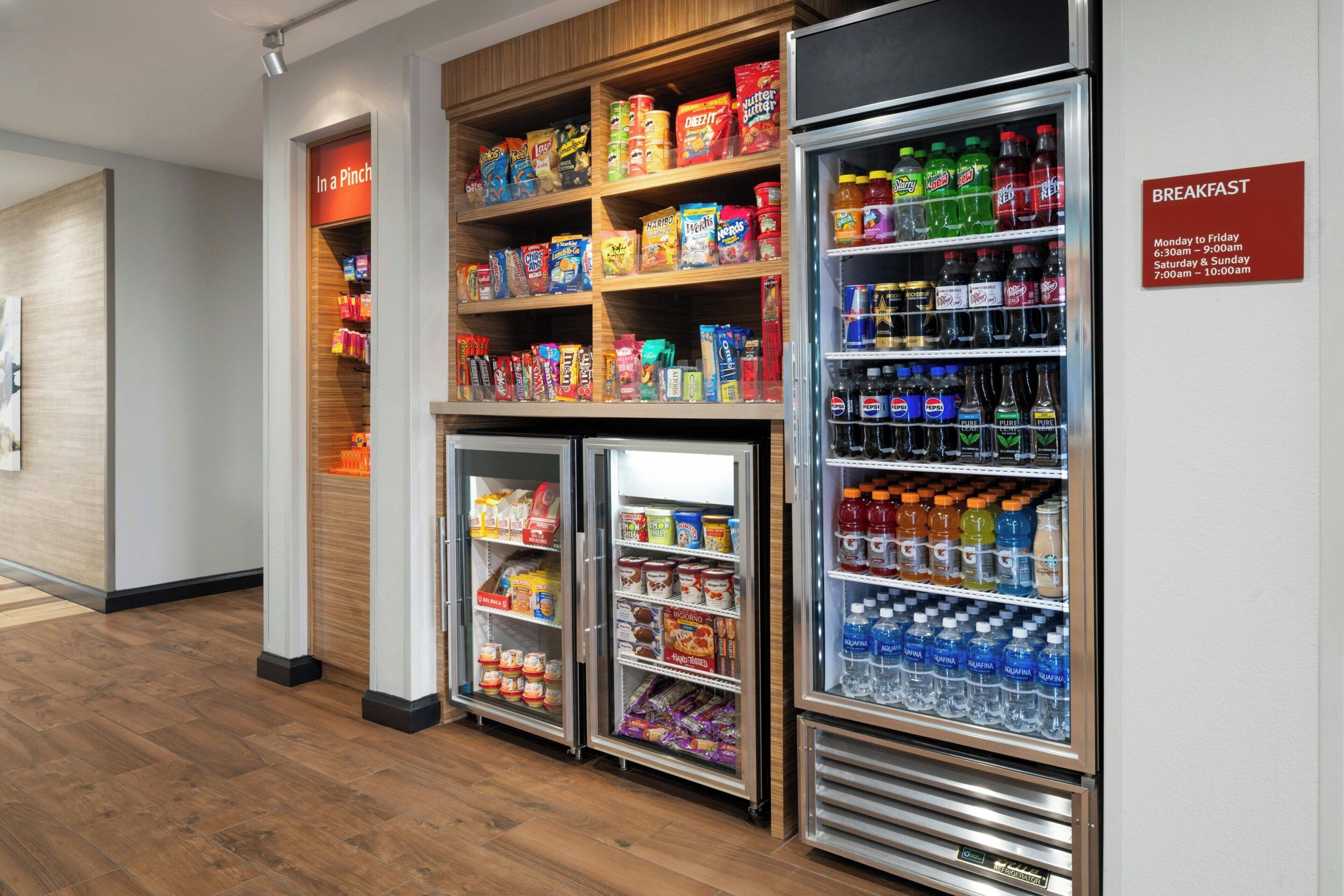 A breakfast area with refrigerated shelves stocked with snacks, beverages, and breakfast items.