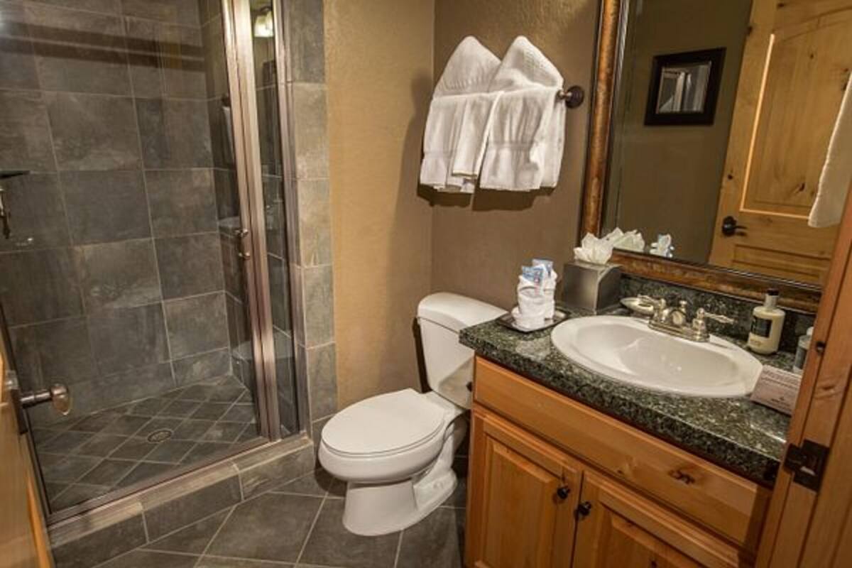 Un baño con ducha, inodoro, lavamanos y toallas.