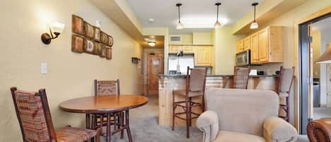 A compact living space with a dining area, kitchen, and seating arrangement.