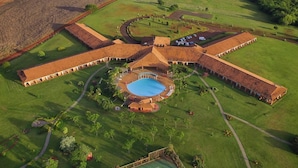 An aerial view of a large estate with a central courtyard, multiple wings, and surrounding fields. - Tenonde Park Hotel (Sao Miguel das Missoes)