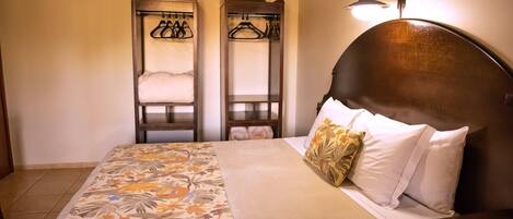 A bedroom with a bed, two wardrobes, and a bedside lamp.