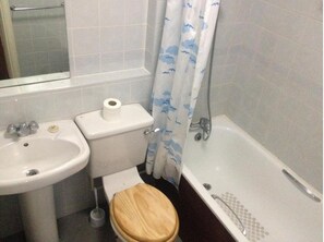 A bathroom with a toilet, sink, and bathtub. - The Welbeck Hotel (Westcliff-on-Sea)
