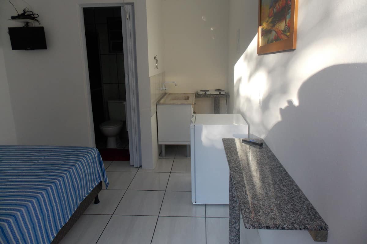 Una habitación pequeña y limpia con cama, lavabo e inodoro.