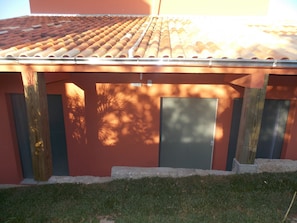 A building with a tiled roof, two doors, and a small window. - Casas da Marli (Imbituba)