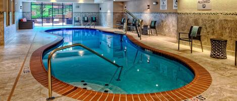 An indoor swimming pool with a curved design, a lifeguard station, and a 'No Diving Allowed' sign.