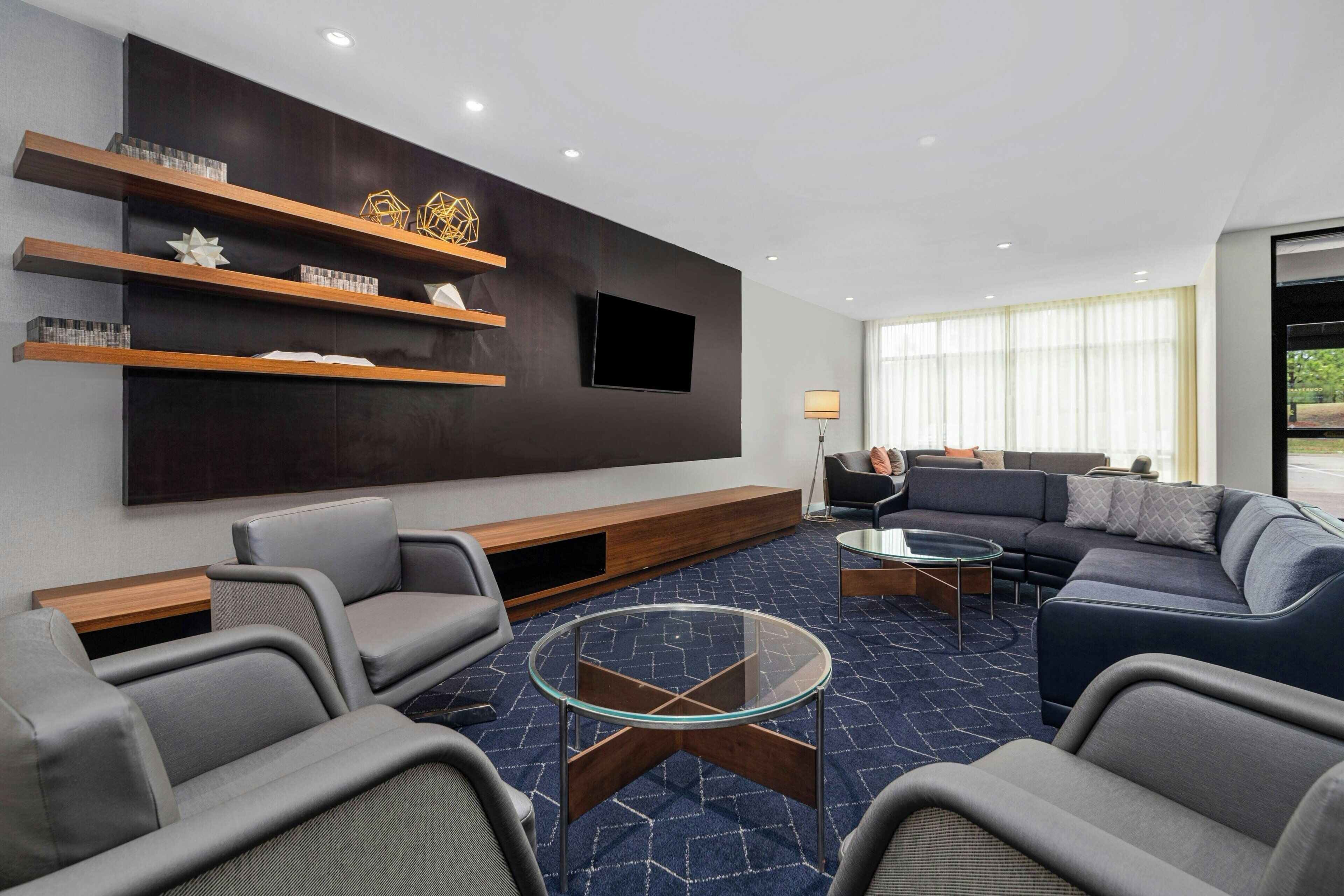 A modern living room with a dark wall, a mounted TV, and a sofa.