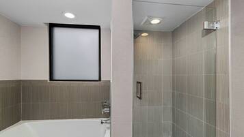 Un baño moderno con bañera, ducha y paredes de azulejos.