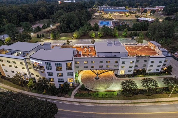 A multi-story hotel with a courtyard, parking, and a swimming pool in the background. - Courtyard by Marriott Oxford (Oxford)