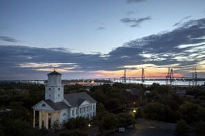 A historic building with a prominent tower and a large central dome, surrounded by trees and a waterfront view. - The Dewberry Charleston (Charleston)
