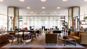 Relax in a spacious lobby with comfortable seating, a dining area, and decorative accents.
