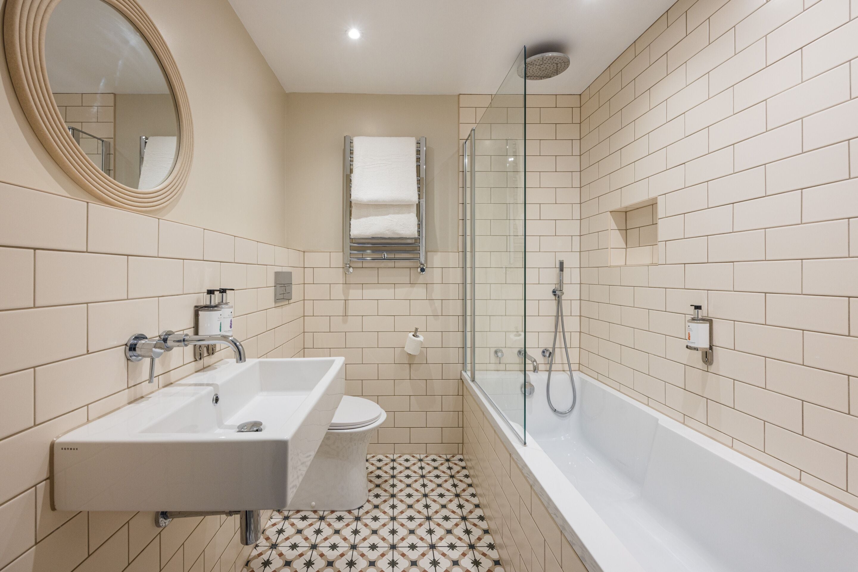 A modern bathroom with two sinks, a toilet, a shower, and a glass-enclosed shower area.