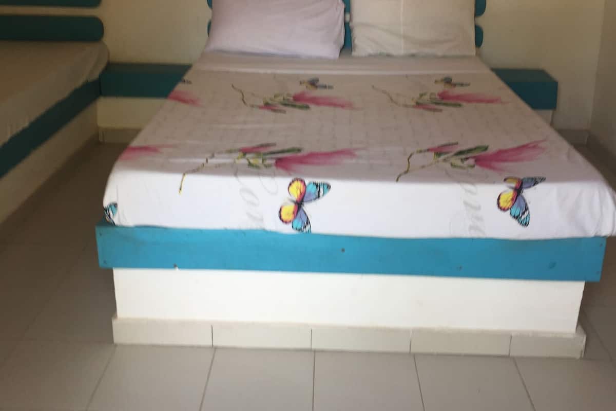 A bed with a floral bedspread and a blue and white headboard.