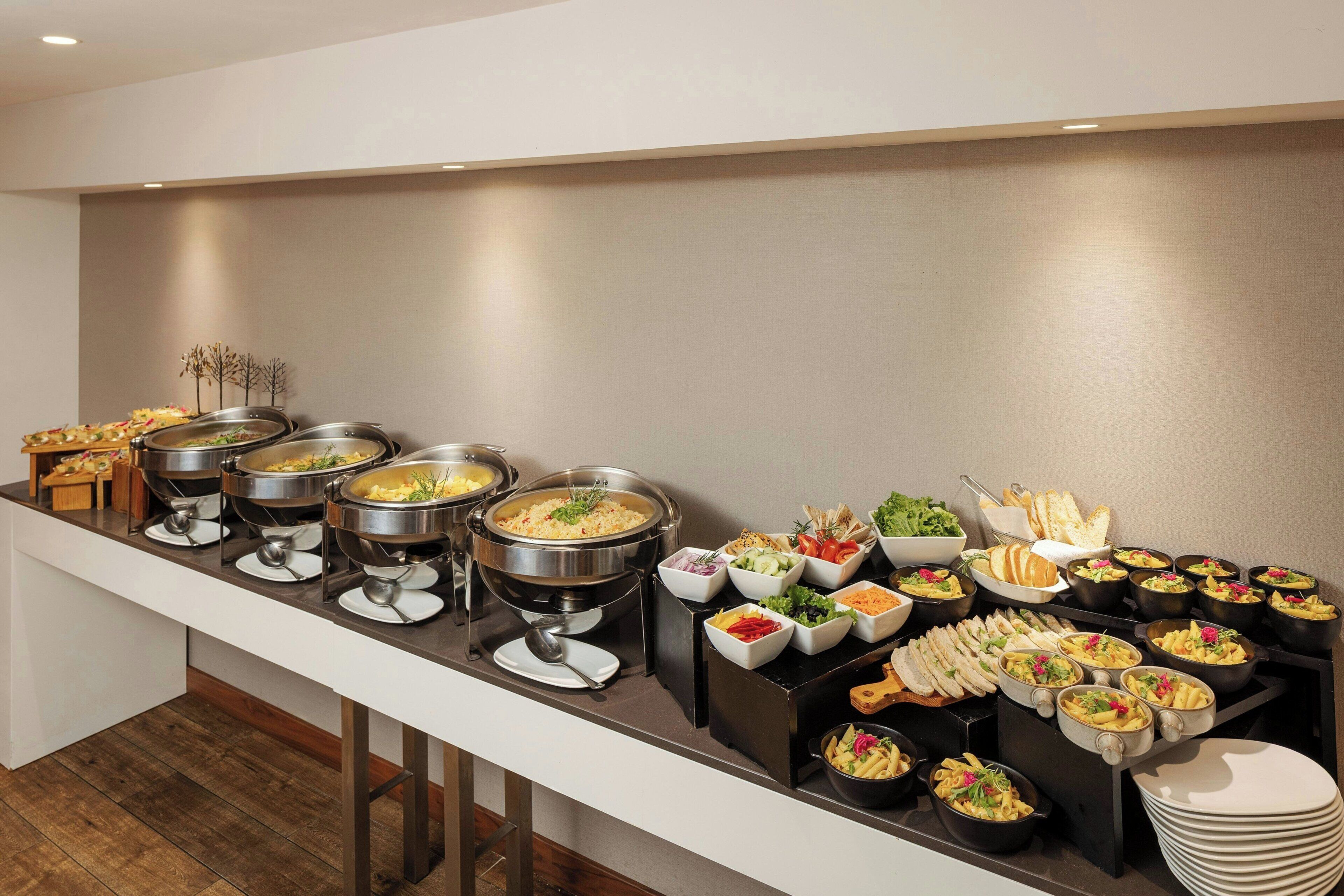 A buffet with various food items and utensils.